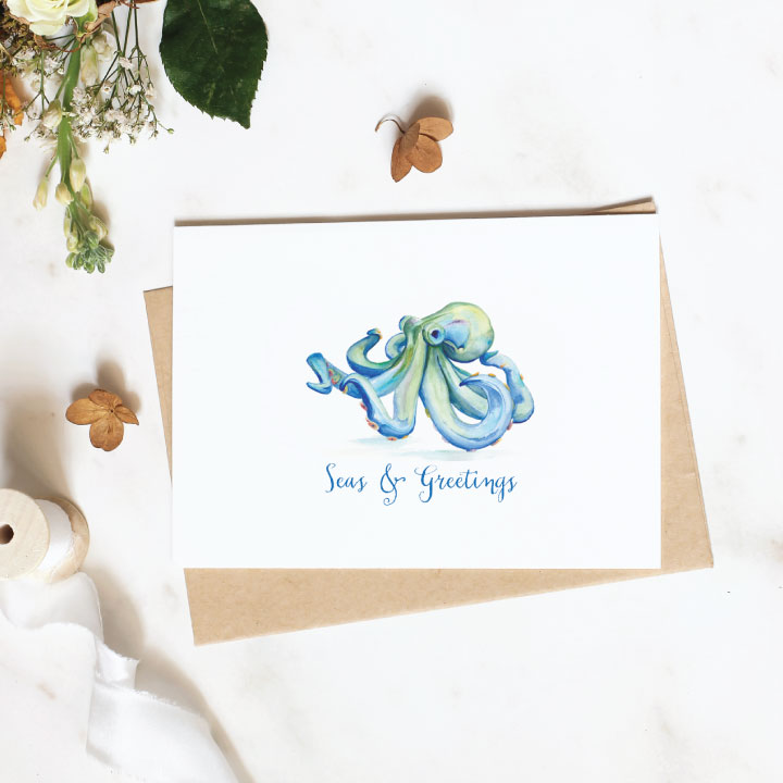 Watercolor Blue Octopus Christmas Cards with the words Seas and Greetings. Artwork and Design by Victoria Rigali 