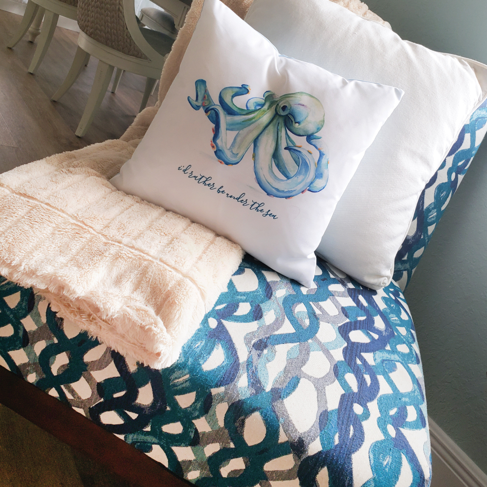 Small space decorating idea. Blue octopus throw pillow on coastal chair with fluffy blanket.